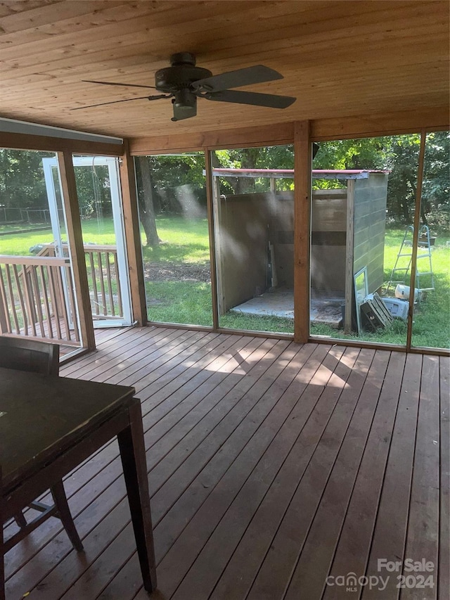 unfurnished sunroom with wood ceiling and ceiling fan