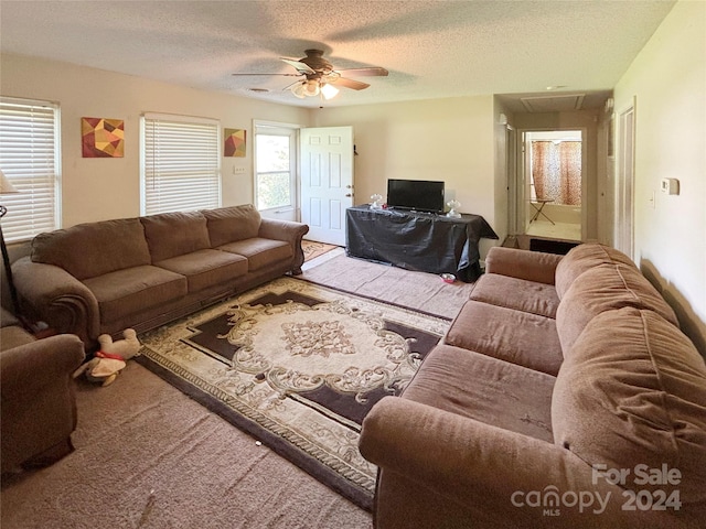 living room featuring a textured ceiling and ceiling fan