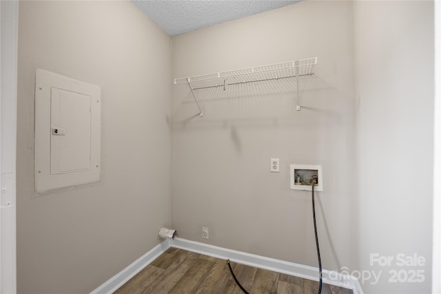 clothes washing area with laundry area, electric panel, baseboards, wood finished floors, and washer hookup