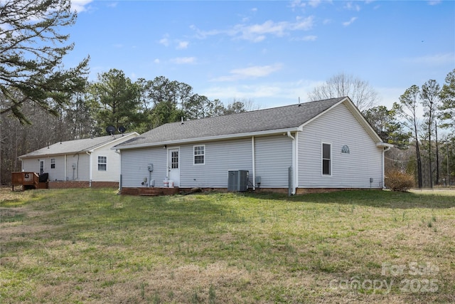 rear view of house with a yard and central AC