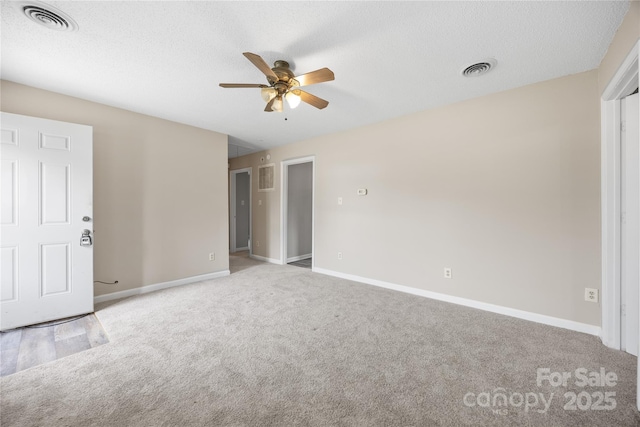 spare room with baseboards, visible vents, and light colored carpet