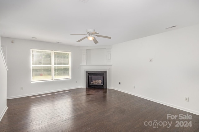 unfurnished living room with dark hardwood / wood-style flooring and ceiling fan