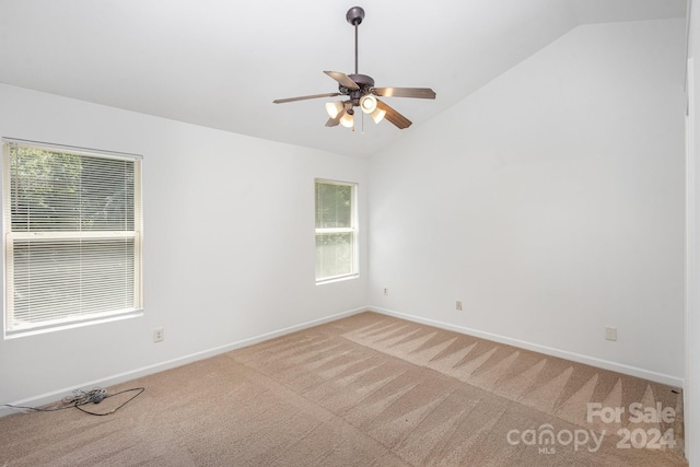 carpeted spare room featuring ceiling fan and vaulted ceiling