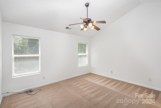 spare room with lofted ceiling, ceiling fan, and light colored carpet