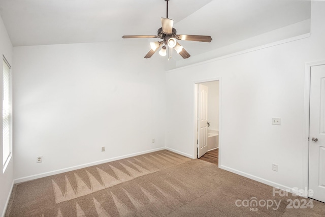 interior space featuring ensuite bath, lofted ceiling, and ceiling fan