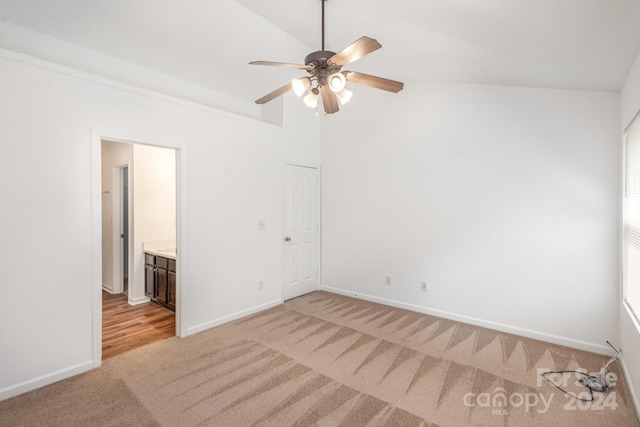 unfurnished room featuring ceiling fan, light carpet, and vaulted ceiling