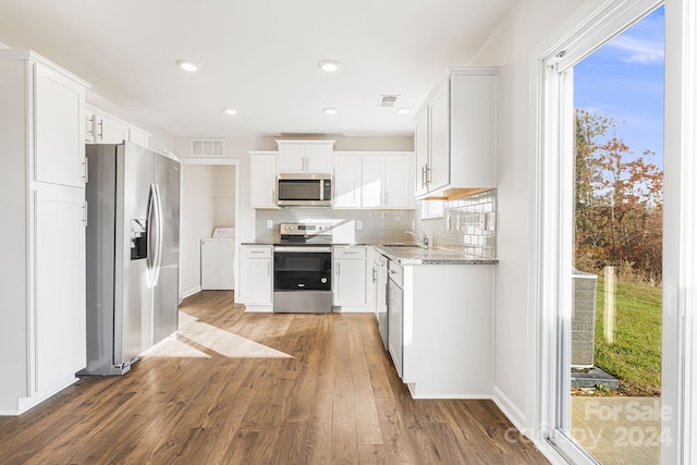 kitchen featuring dark wood-type flooring, white cabinets, sink, light stone counters, and stainless steel appliances