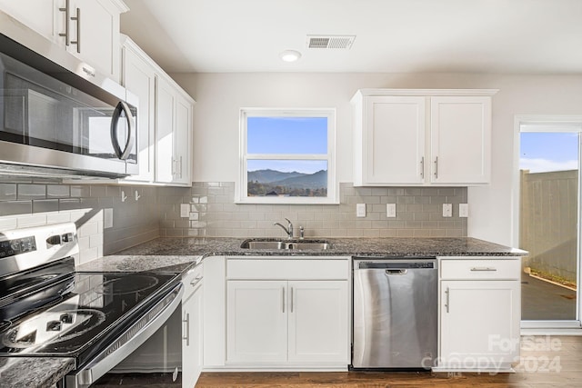 kitchen featuring white cabinets, stainless steel appliances, plenty of natural light, and sink