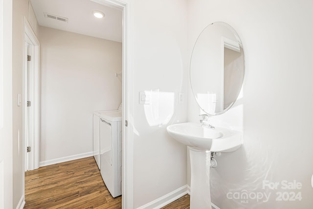 bathroom with hardwood / wood-style floors and washing machine and clothes dryer