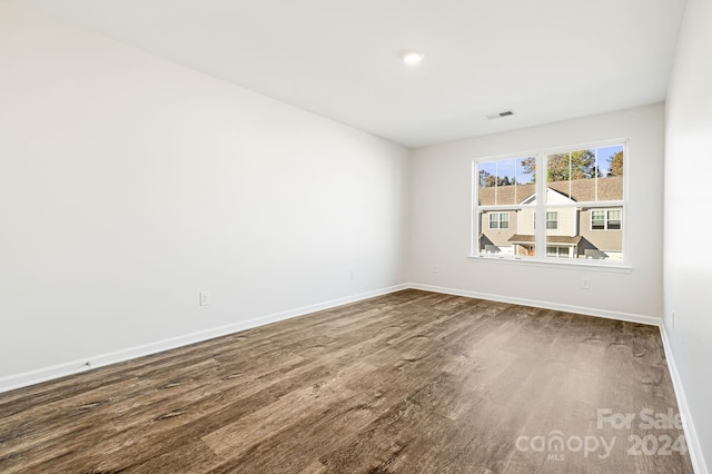 unfurnished room with dark wood-type flooring