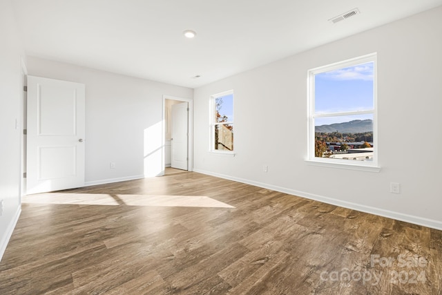 unfurnished room featuring a mountain view and hardwood / wood-style floors