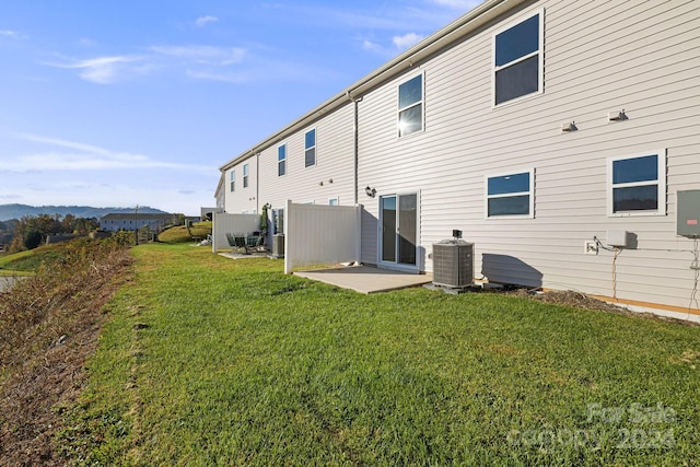 back of property with a lawn and central air condition unit