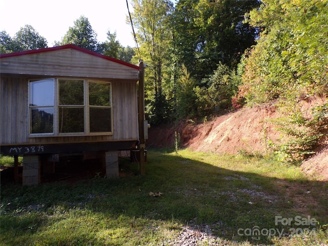 view of side of home with a yard