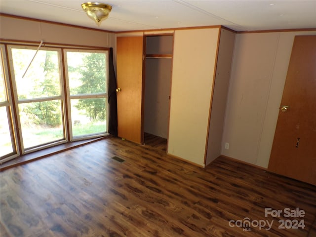 unfurnished bedroom featuring wood finished floors, visible vents, and crown molding