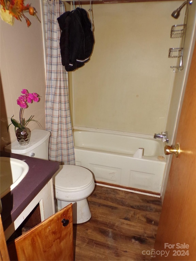 bathroom featuring vanity, shower / tub combo, wood finished floors, and toilet