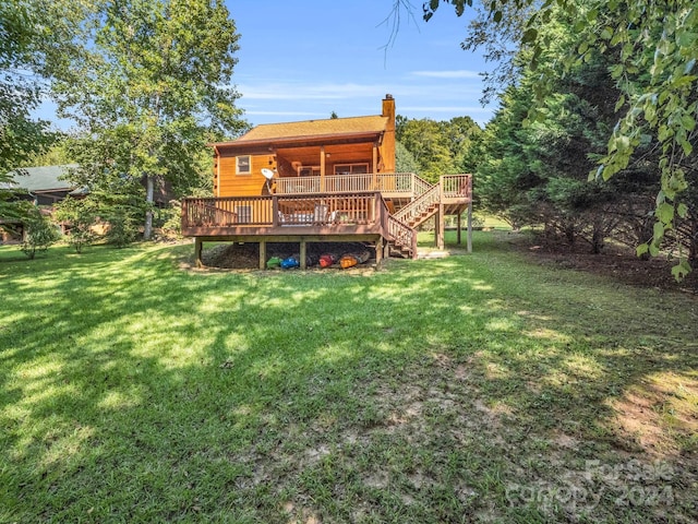 rear view of house featuring a deck, a lawn, a chimney, and stairs