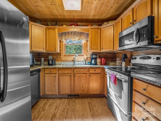 kitchen with light stone counters, stainless steel appliances, a sink, wood ceiling, and light wood-style floors