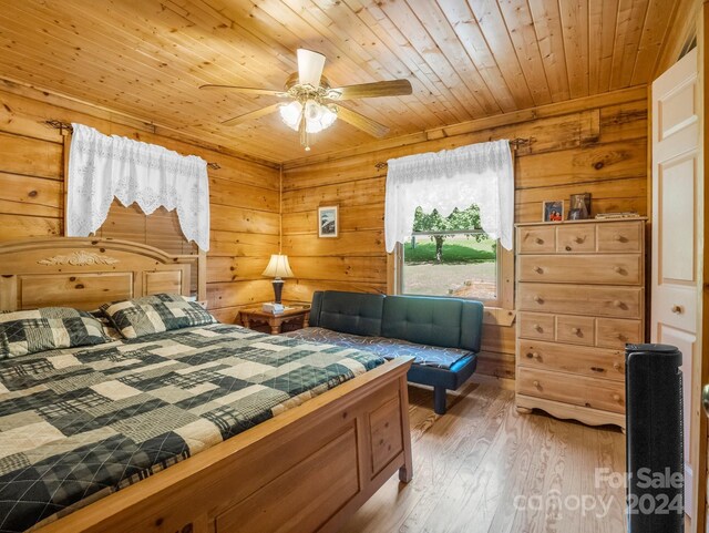 bedroom featuring ceiling fan, wood ceiling, wood walls, and wood finished floors