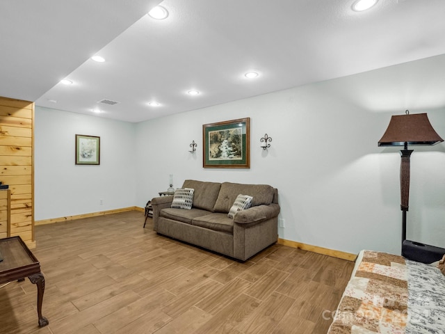 living room featuring baseboards, recessed lighting, visible vents, and light wood-style floors