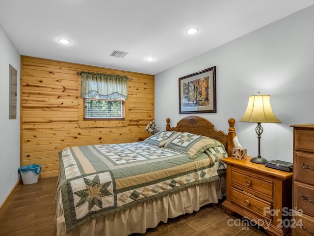 bedroom featuring dark wood-style floors, recessed lighting, visible vents, and wooden walls