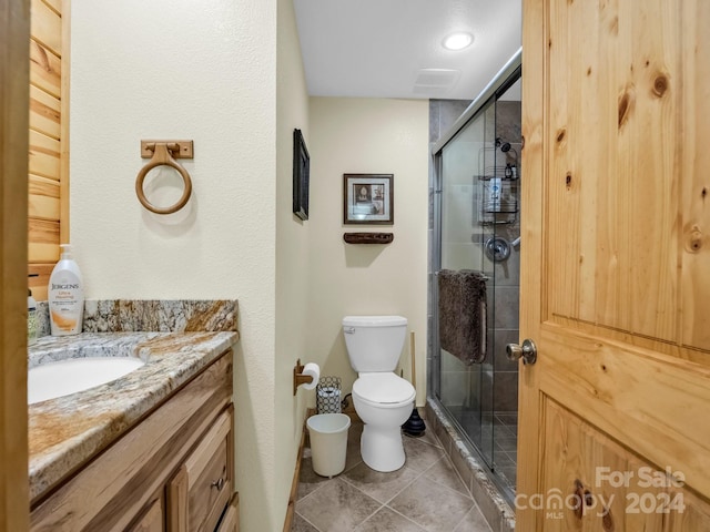 full bathroom featuring vanity, tile patterned flooring, a shower stall, and toilet