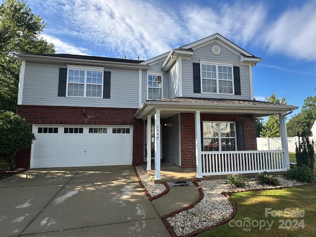 view of property with a garage and covered porch