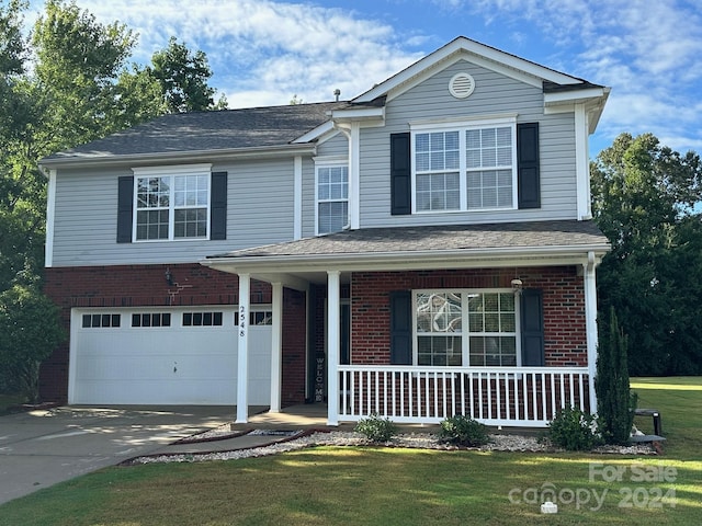 view of front property with a front yard, covered porch, and a garage