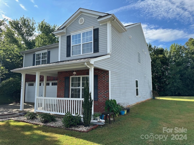 front facade featuring a garage, a front yard, and a porch