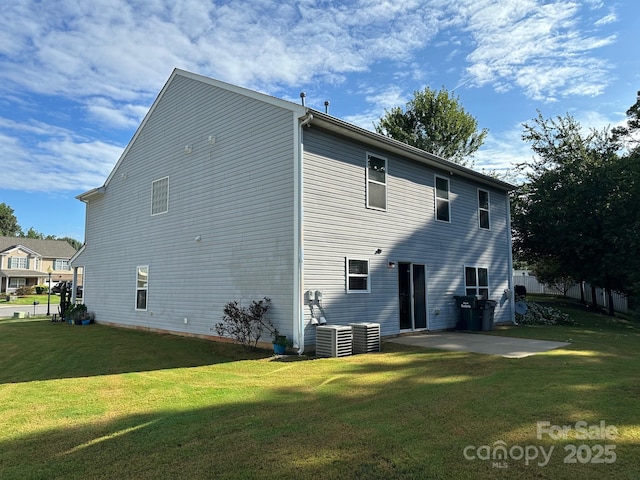 back of house with central AC unit, a lawn, and a patio