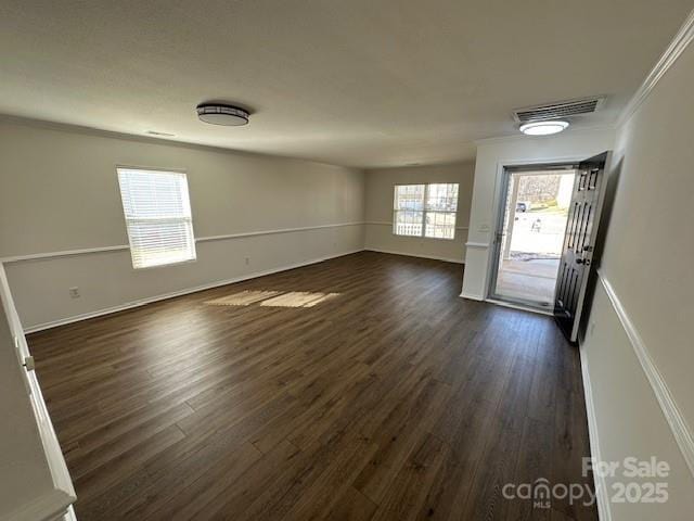 entrance foyer featuring dark wood-style flooring, visible vents, and crown molding