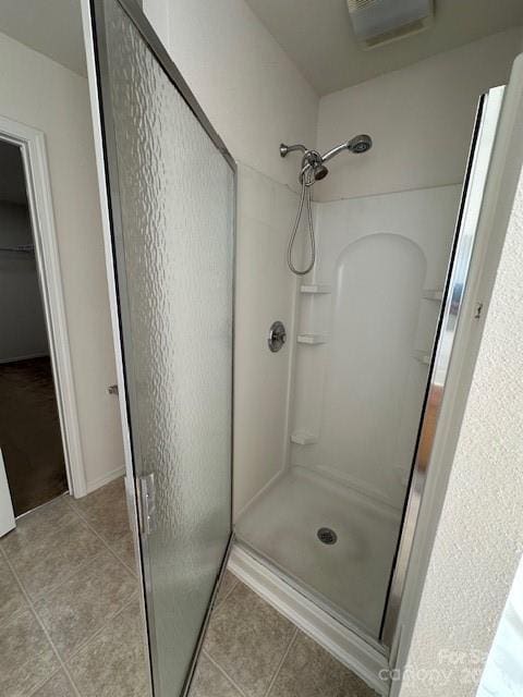 full bathroom with tile patterned flooring, visible vents, and a shower stall