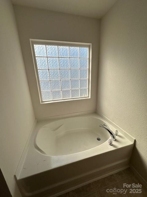 full bathroom featuring a garden tub and tile patterned floors