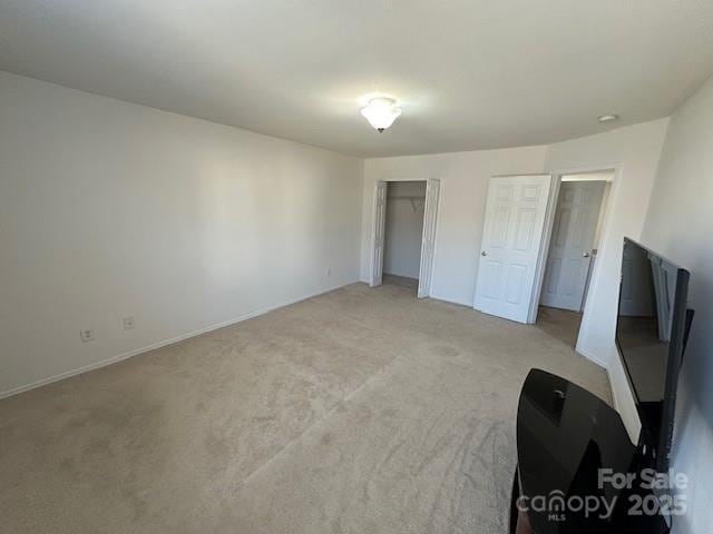 unfurnished bedroom with light carpet and multiple closets