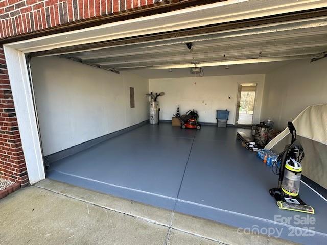 garage with electric panel and water heater