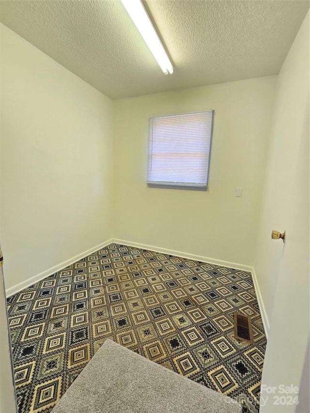 spare room with a textured ceiling