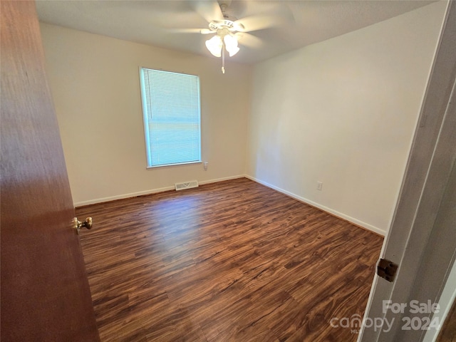 empty room with dark hardwood / wood-style floors and ceiling fan