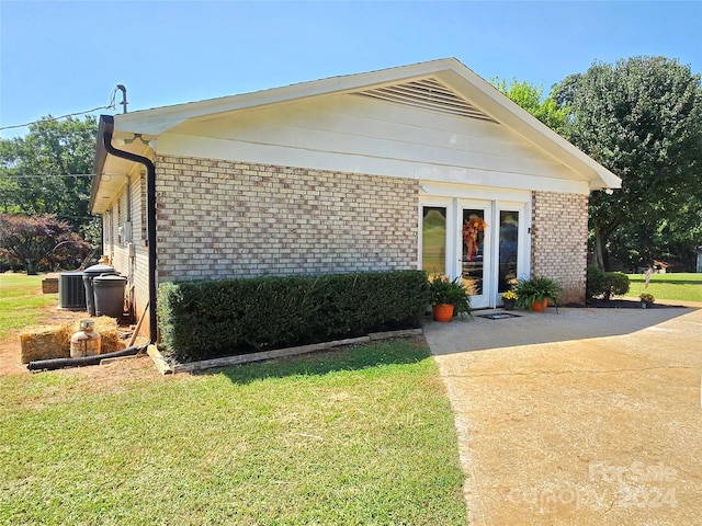 view of front facade with a front lawn and central AC