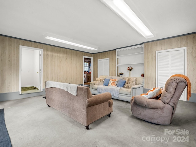 carpeted living room with wood walls