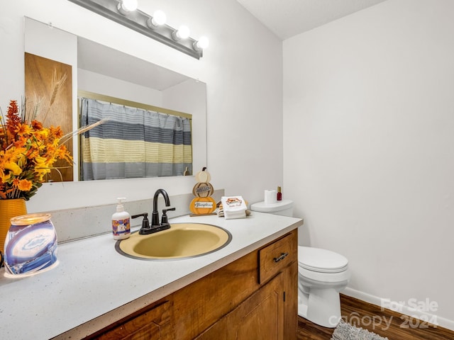 bathroom with curtained shower, vanity, toilet, and hardwood / wood-style flooring