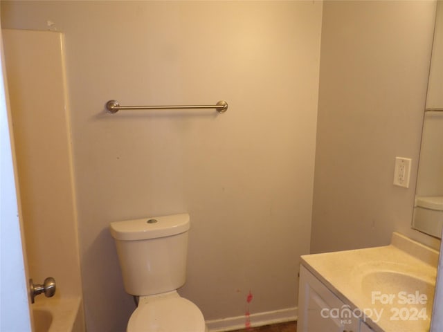 full bathroom featuring toilet, a tub to relax in, and vanity