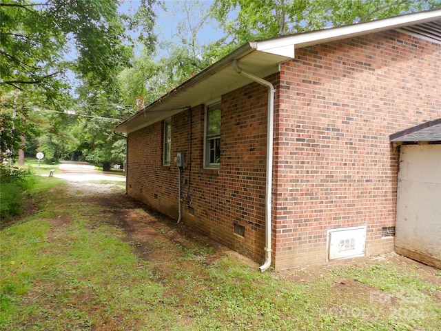 view of side of property with brick siding and crawl space