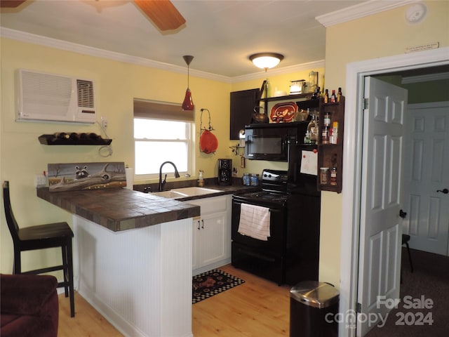 1555 Soco Rd Unit 6, Maggie Valley, NC 28751 - kitchen with black appliances, light wood finished floors, ornamental molding, a wall mounted AC, and white cabinetry