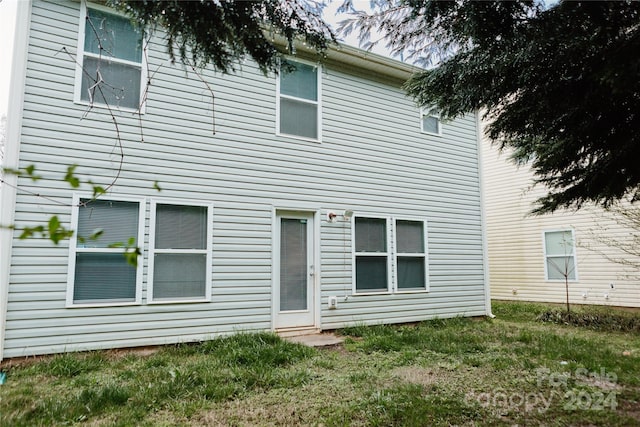 rear view of property featuring a lawn