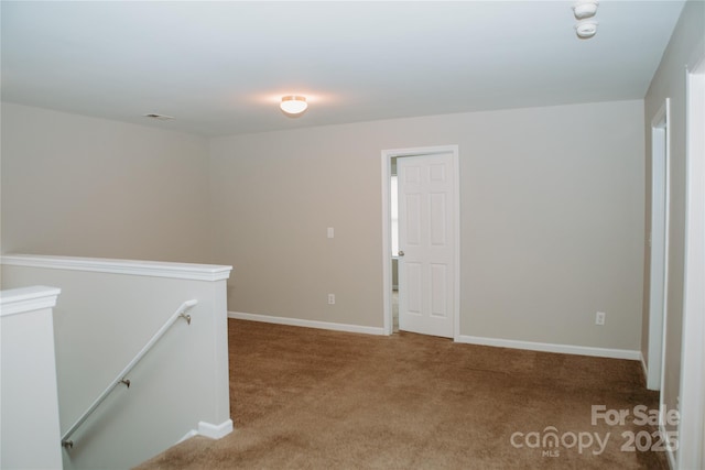 carpeted empty room featuring baseboards and visible vents