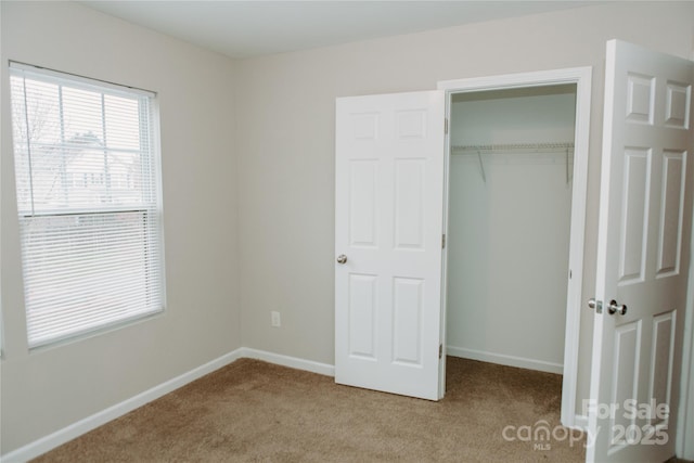 unfurnished bedroom featuring a closet, carpet floors, and baseboards