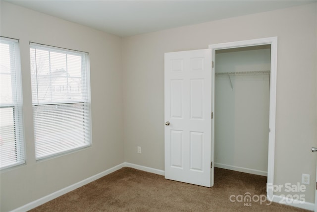 unfurnished bedroom with a closet, baseboards, and carpet