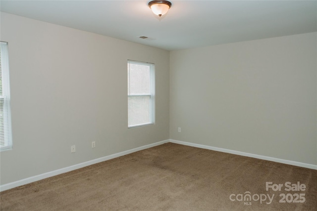 unfurnished room featuring baseboards, visible vents, carpet floors, and a healthy amount of sunlight