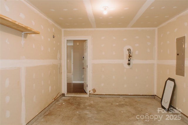 empty room with electric panel and unfinished concrete flooring