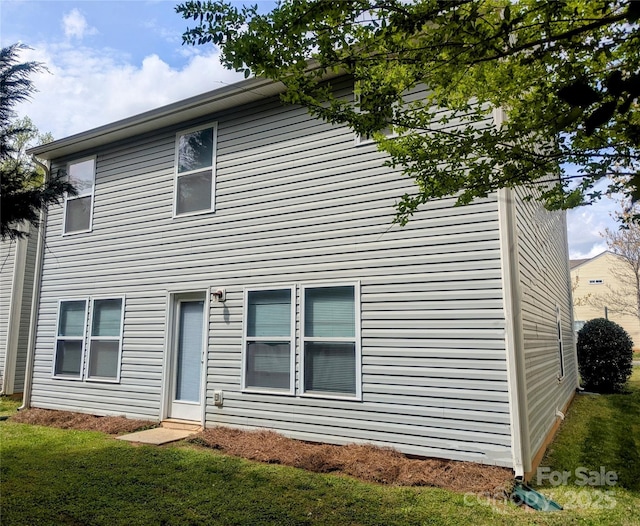 rear view of house featuring a yard