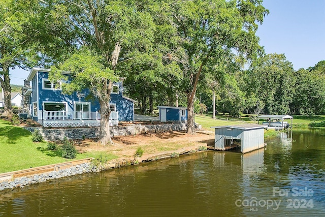 view of dock featuring a water view and a yard